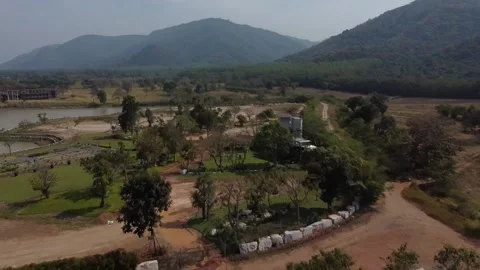 Flying backwards through forest and field with mountain view, Thailand Stockbeeldmateriaal 148847314
