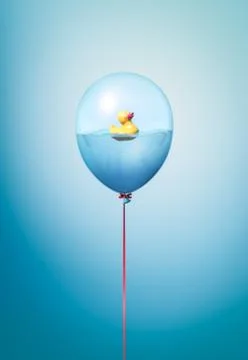 Flying balloon copy space idea with yellow rubber duck on blue background Stock Photos
