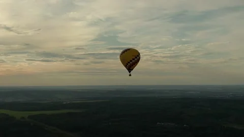Flying in balloons over a green field and forest Video stock 136236953