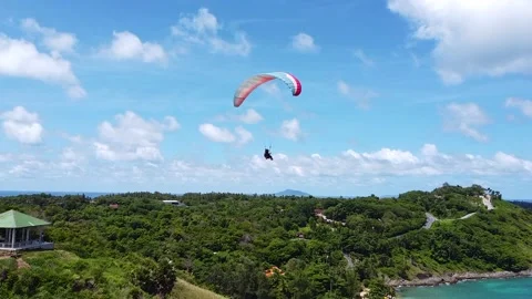 Flying behind a paraglide, drone view of a paraglide over a tropical island 動画素材 173720973