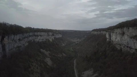 Flying between cliffs on a cloudy weather 1080 ungraded Stock Footage 105953380