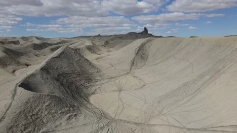 Flying between the hills of a dry arid desert landscape with motorcycle tracks Stock Footage 153872270