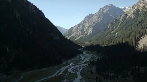 Flying between mountains over the mouth of a mountain river Stock Footage 297315113