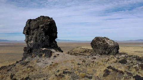 Flying between volcanic rocks to reveal vast desert Stock Footage 120816576