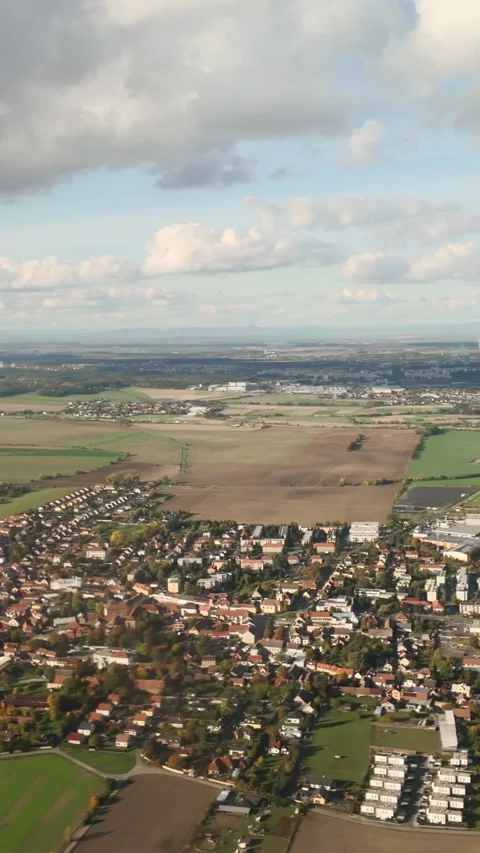 Flying in blue sky beneath cumulus clouds over green fields and houses on Stock Footage 325073472