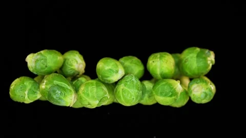 Flying Brussels sprouts infront of black background in slowmotion Stock Footage 163202728
