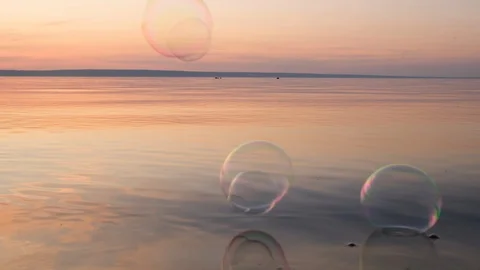Flying bubbles over the water at sunset. Anti-stress video. Abstract video. Stock Footage 114990278