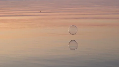 Flying bubbles over the water at sunset. Anti-stress video. Abstract video. Stock Footage 115015040