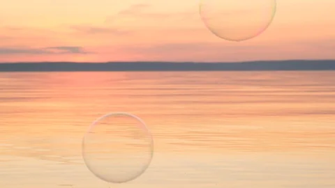 Flying bubbles over the water at sunset. Anti-stress video. Abstract video. Stock Footage 115015081
