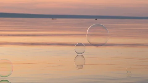 Flying bubbles over the water at sunset. Anti-stress video. Abstract video. Stock Footage 115016046