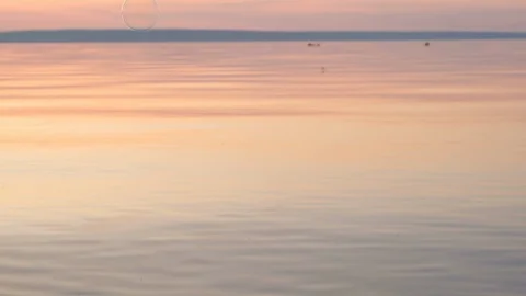 Flying bubbles over the water at sunset. Anti-stress video. Abstract video. Stock Footage 115016244