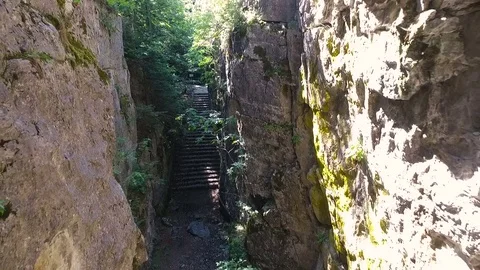 Flying camera aerial between rocks in canyon. Video stock 80294139