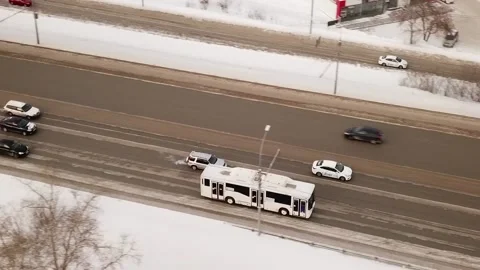 A flying camera chases a white bus that moves on a snowy road Stock Footage 147005445