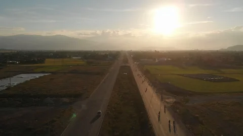 A flying camera flies beautifully a view of the sunset, forest, road Stock Footage 116114647