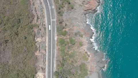 A flying camera flies over a beautiful rocky sea overlooking the winding road 스톡 동영상 117445285