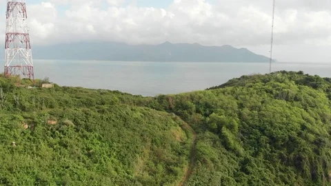 A flying camera flies over the jungle overlooking the island’s sea. Vietnam Stock Footage 115271107