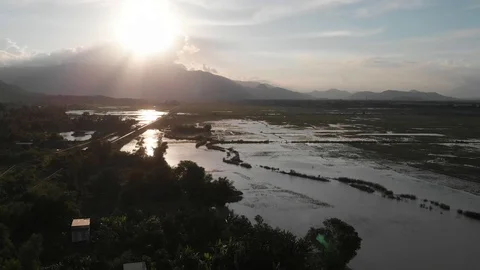 A flying camera flies over a railroad in Vietnam overlooking rice fields Stock Footage 100188702