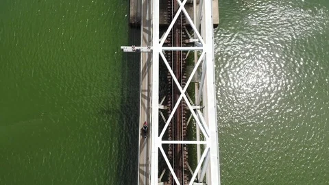 A flying camera flies over a railway bridge stretched across a river  Vietnam Video stock 100188077