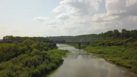A flying camera monitors a freight train moving across the bridge Video stock 141501025