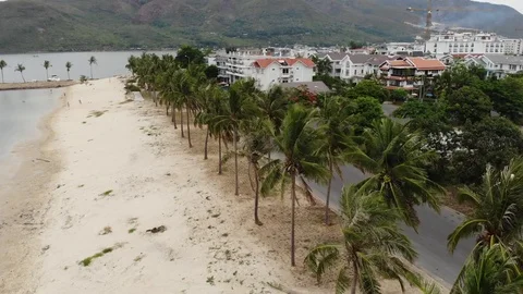 A flying camera over the beach of Nha Trang Vietnam sea island of palm trees Vídeos de archivo 100187385