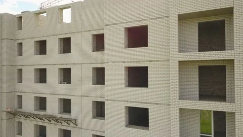 A flying camera removes the empty windows of a building under construction. Vídeo Stock 133622357
