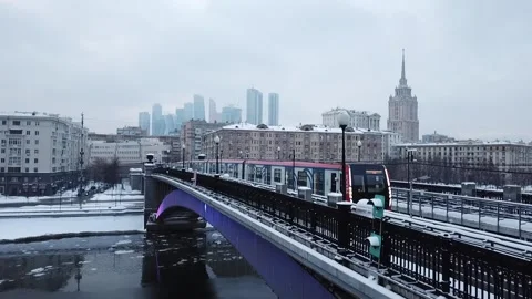 The flying camera slowly flies up to the bridge on which the metro train Video stock 169071760