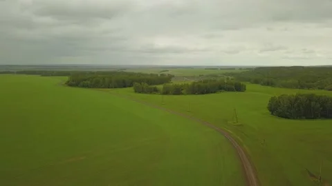 A flying camera takes a green field in Siberia Stock Footage 133622216