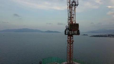 A flying camera takes off a tower crane near a construction Stock Footage 119131544