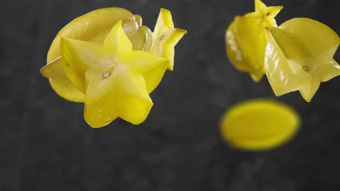 Flying Carambola and Star Fruit slices in Dark Kitchen Background Stock Footage 229561053