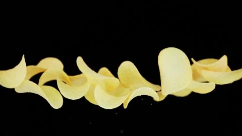Flying chips infront of black background in slowmotion Stock Footage 163216483