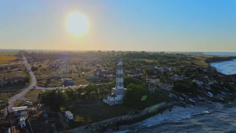 Flying in a circle around an old lighthouse while the sun is setting, cinema Stock Footage 135646752