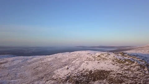 Flying in a clear sky above low clouds over a snow-covered  mountain Stock-Footage 143709696