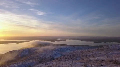 Flying in a clear sky above low clouds over a snow-covered  mountain Stock-Footage 143709782