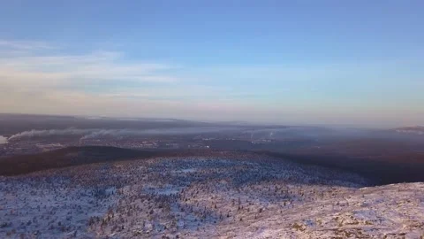Flying in a clear sky above low clouds over a snow-covered  mountain Stock-Footage 143709988