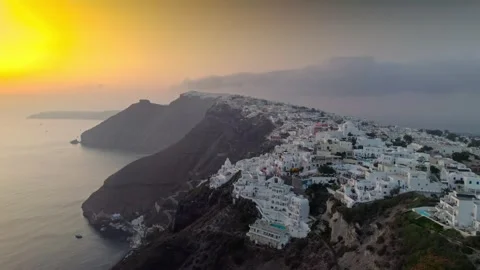 Flying to cliffside buildings over the ocean at sunset 4K Stock Footage 314753962