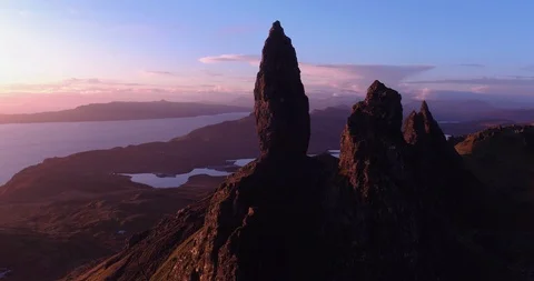 Flying close around Old Man Storr with red glow from sunrise drone aerial 4K Stock Footage 104580281
