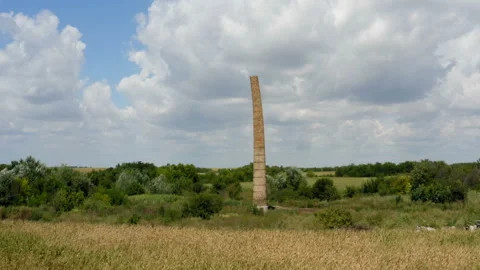 Flying close to a old brick chimney in the middle of the field Stockbeeldmateriaal 137719908