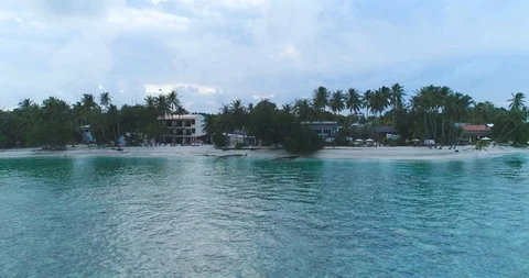 Flying close over tropical island with palm trees sandy beach and waves Stock-Footage 89943765