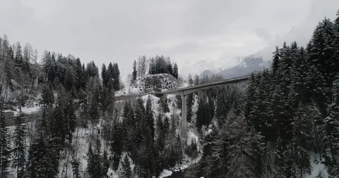 Flying close to trees over a snowy road in Switzerland Stock Footage 92529248