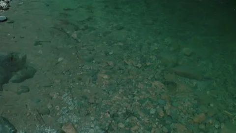 Flying closely over the watersurface of a shallow mountain river Stock Footage 160326737