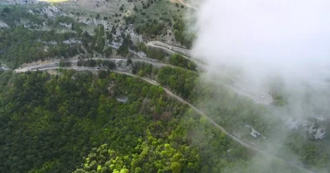 Flying In Clouds Above Serpentine Road Stock-Footage 63334490