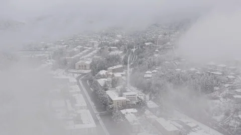 Flying in the clouds above snowy town, Georgia (country) Video stock 124938469