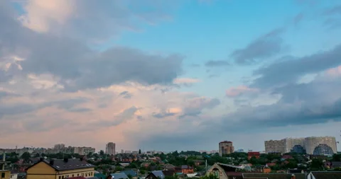 Flying clouds at sunset against a cityscape Stock Footage 112613208