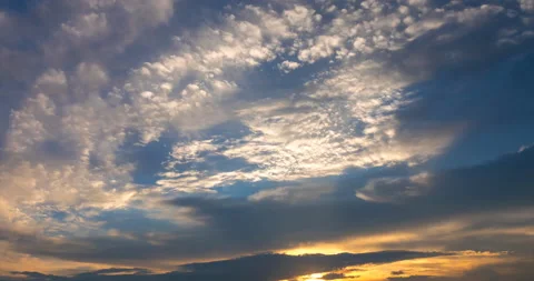 Flying clouds at sunset, illuminated by the rays of the setting sun Stock Footage 92576050