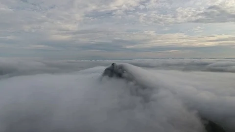 Flying with the clouds towards the mountain peak Stock Footage 81139032