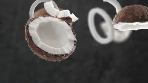 Flying Coconut and Coconuts slices in Dark Kitchen Background Stock Footage 232747542