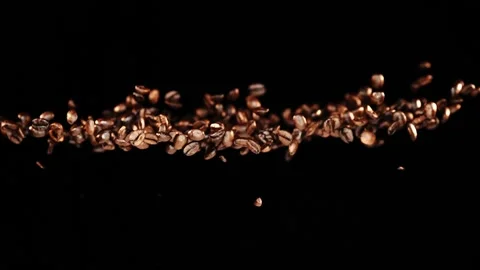 Flying coffee beans infront of black background in slowmotion Stock Footage 163216192