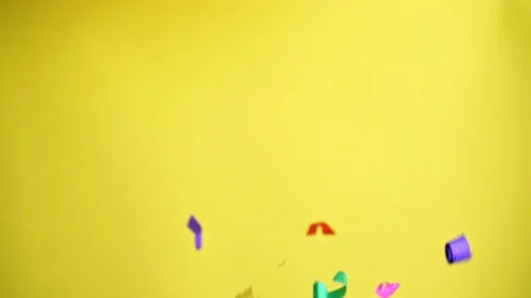 Flying confetti in 4K on yellow background Stock Footage 104040078