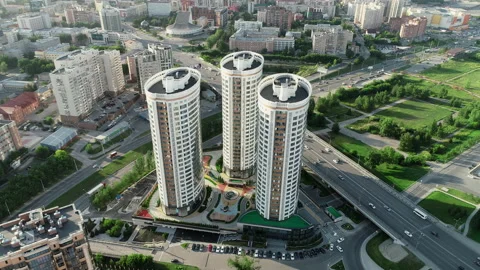 Flying a copter around three modern buildings against the backdrop of the city Stock Footage 142896031