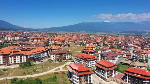 Flying copter over the red roofs rural town in mountains 스톡 동영상 114685821